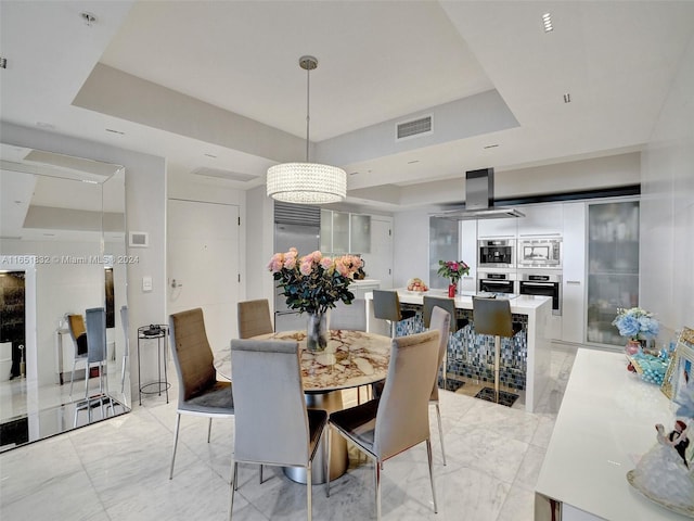 dining area featuring a tray ceiling and a chandelier