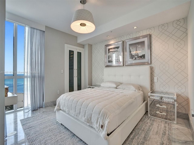 bedroom with french doors and a water view