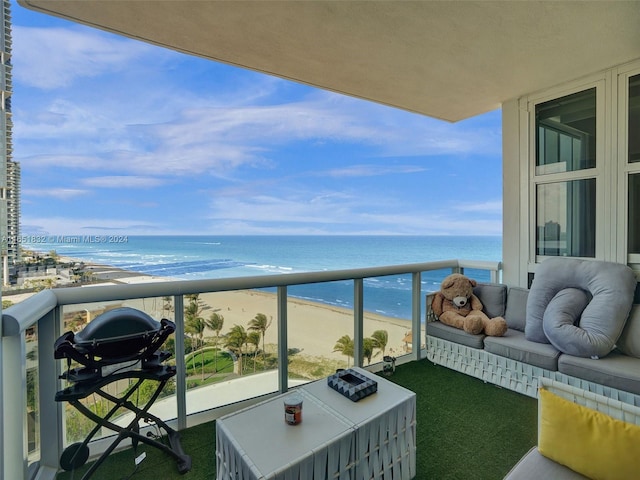 balcony featuring a view of the beach and a water view