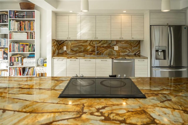 kitchen with sink, light stone countertops, appliances with stainless steel finishes, and decorative backsplash