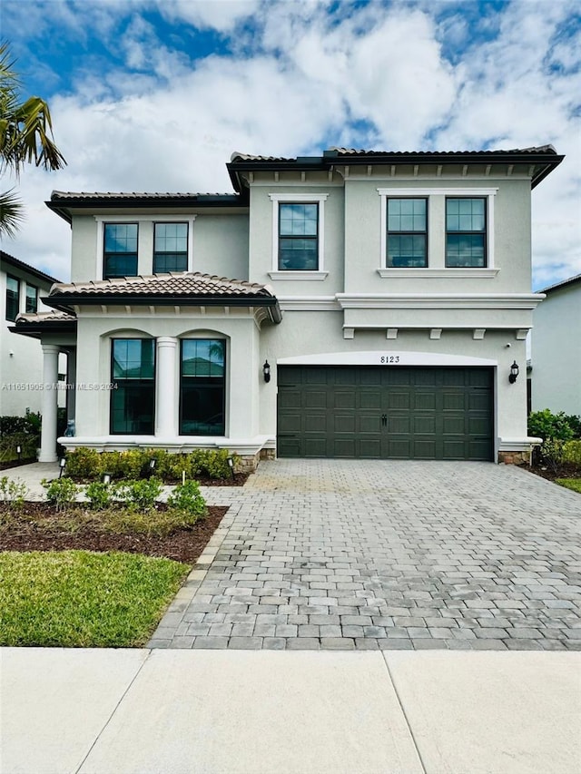 8123 NW 78th St, Tamarac, FL 33321 - mediterranean / spanish home with stucco siding, decorative driveway, a garage, and a tiled roof