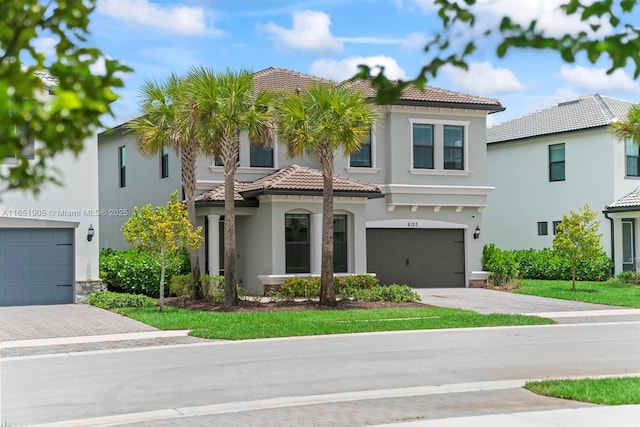 8123 NW 78th St, Tamarac, FL 33321 - mediterranean / spanish house with driveway, a garage, a tile roof, and stucco siding