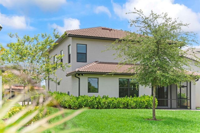 8123 NW 78th St, Tamarac, FL 33321 - back of house featuring a tiled roof, stucco siding, and a lawn