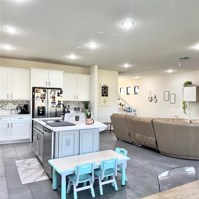 8123 NW 78th St, Tamarac, FL 33321 - kitchen with stainless steel appliances, open floor plan, decorative backsplash, recessed lighting, and a textured ceiling