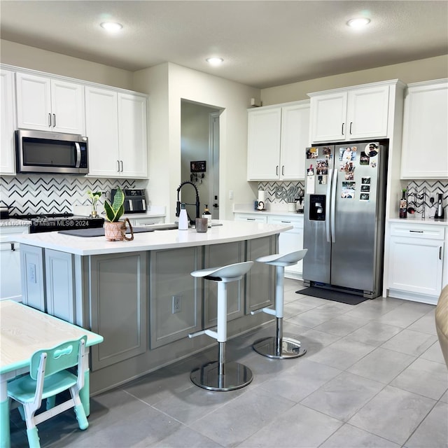 8123 NW 78th St, Tamarac, FL 33321 - kitchen with appliances with stainless steel finishes, decorative backsplash, light countertops, a sink, and white cabinetry