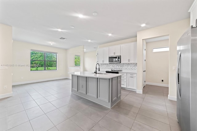 8123 NW 78th St, Tamarac, FL 33321 - kitchen featuring appliances with stainless steel finishes, decorative backsplash, light countertops, light tile patterned floors, and white cabinets