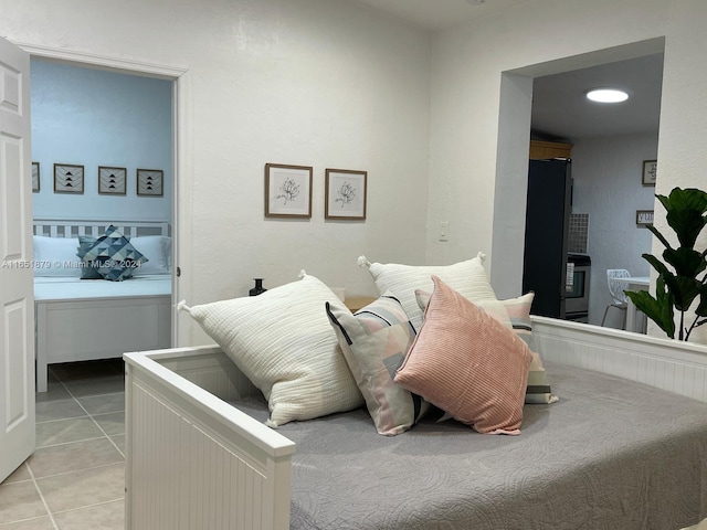 bedroom featuring black refrigerator and light tile patterned floors