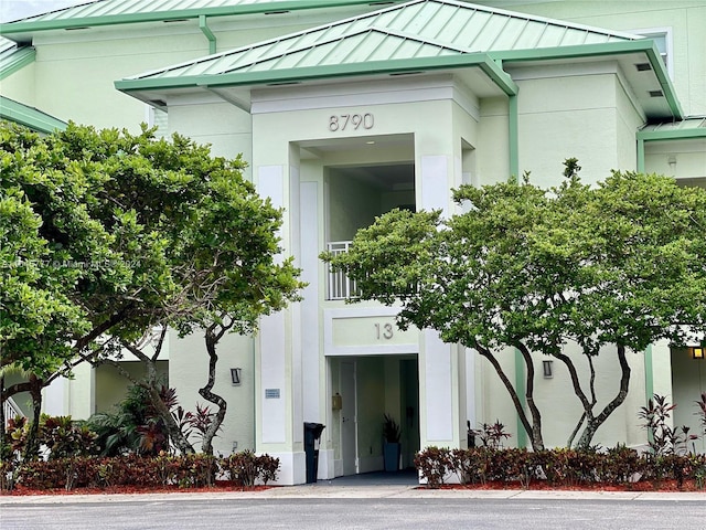 entrance to property with a standing seam roof, metal roof, and stucco siding