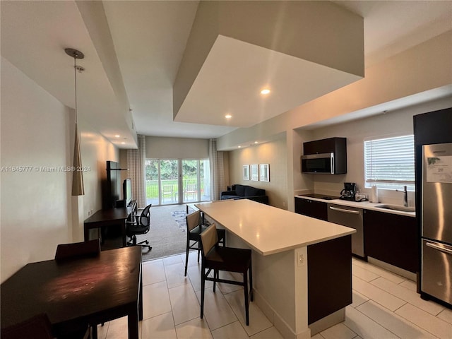 kitchen with light countertops, a healthy amount of sunlight, stainless steel appliances, a kitchen island, and a breakfast bar area