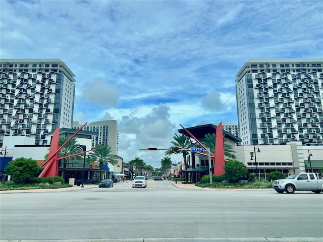 view of street with sidewalks, street lights, curbs, and traffic lights