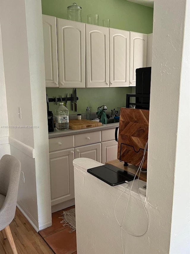 kitchen with white cabinetry and light hardwood / wood-style flooring