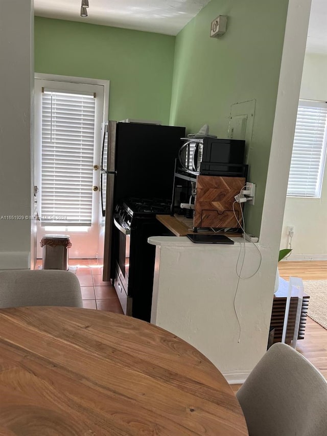 kitchen with stainless steel range, a healthy amount of sunlight, and light wood-type flooring