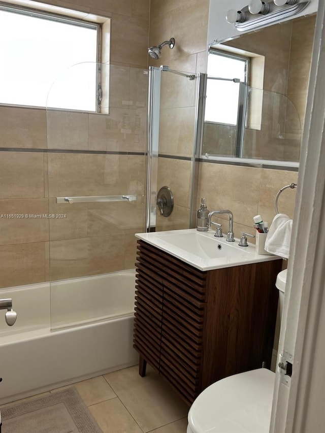 full bathroom featuring vanity, tiled shower / bath, a healthy amount of sunlight, and toilet