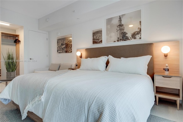 tiled bedroom with a closet and a spacious closet