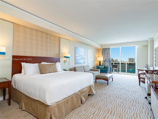 bedroom with light colored carpet, a wall of windows, and access to outside