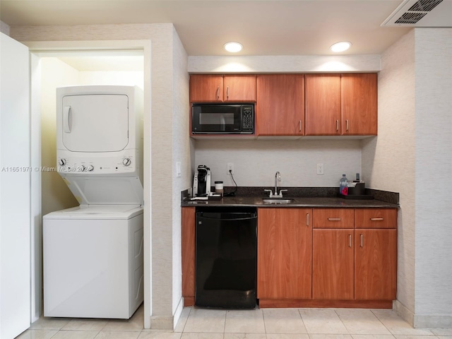 kitchen featuring light tile patterned floors, stacked washer and dryer, sink, and black appliances