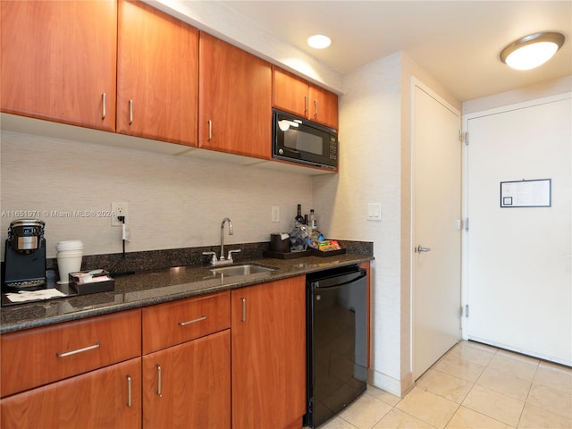 kitchen with black appliances, sink, dark stone countertops, and light tile patterned floors