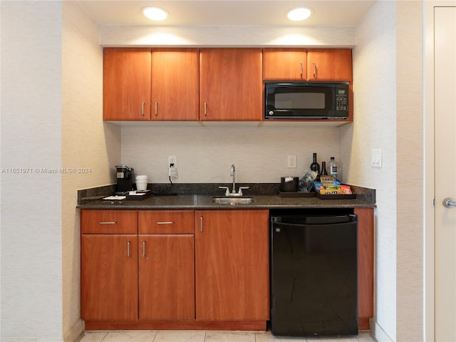 kitchen featuring light tile patterned floors, dark stone counters, sink, and black appliances