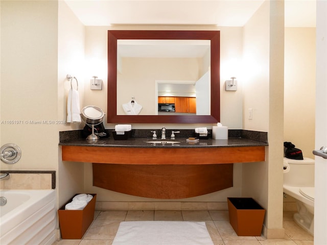 bathroom with vanity, tile patterned flooring, toilet, and a bathtub