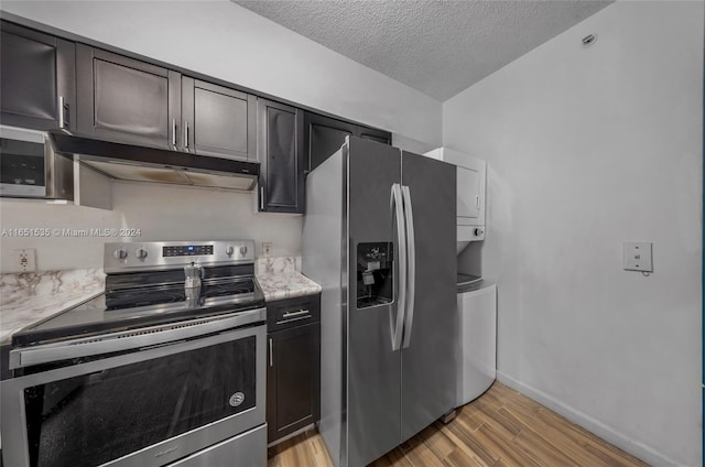 kitchen featuring a textured ceiling, stainless steel appliances, and light hardwood / wood-style flooring