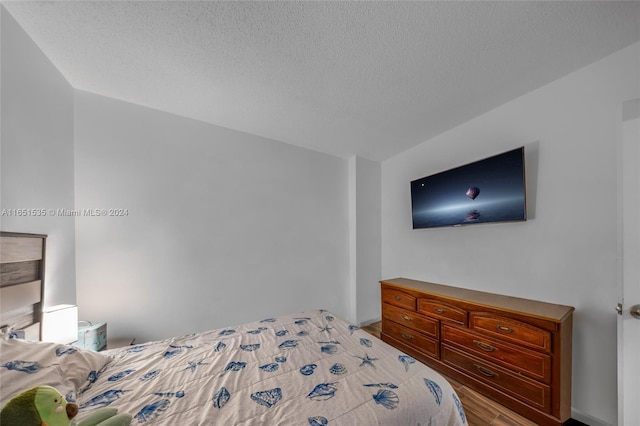 bedroom featuring a textured ceiling and hardwood / wood-style floors