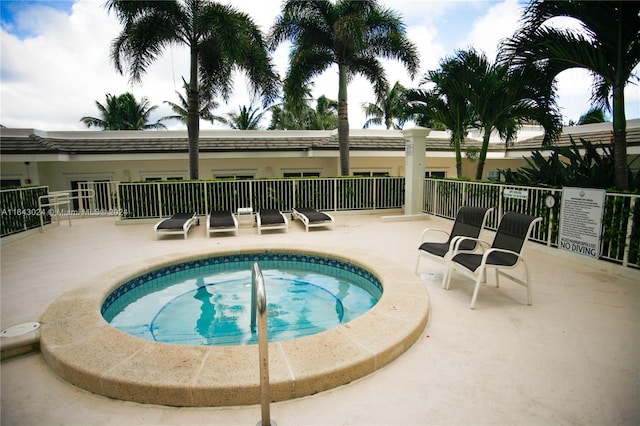 view of swimming pool featuring a hot tub