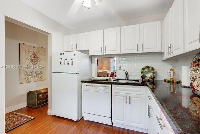 kitchen with white cabinets, white appliances, ceiling fan, and light hardwood / wood-style flooring