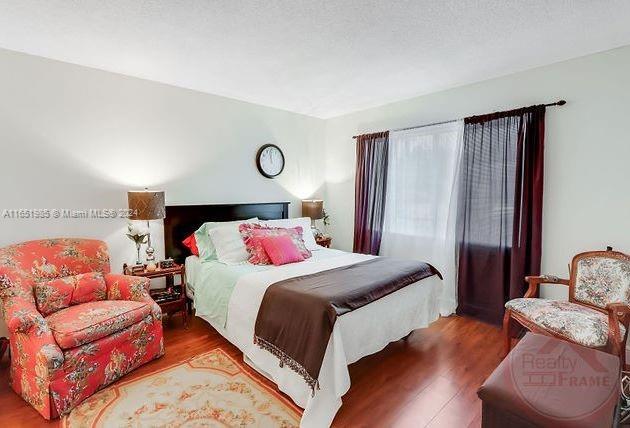 bedroom with hardwood / wood-style floors and a textured ceiling