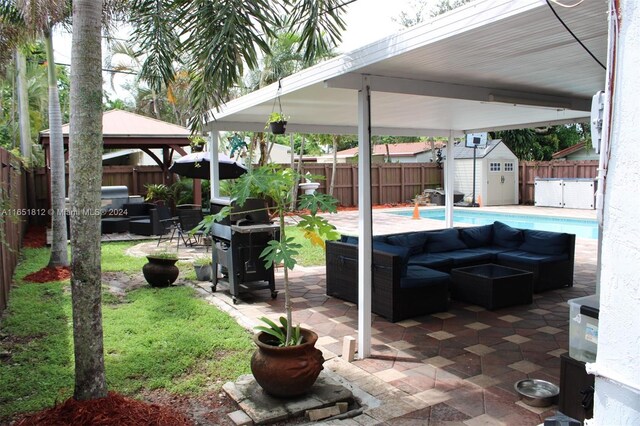 view of patio with a shed, an outdoor hangout area, a fenced in pool, and a gazebo