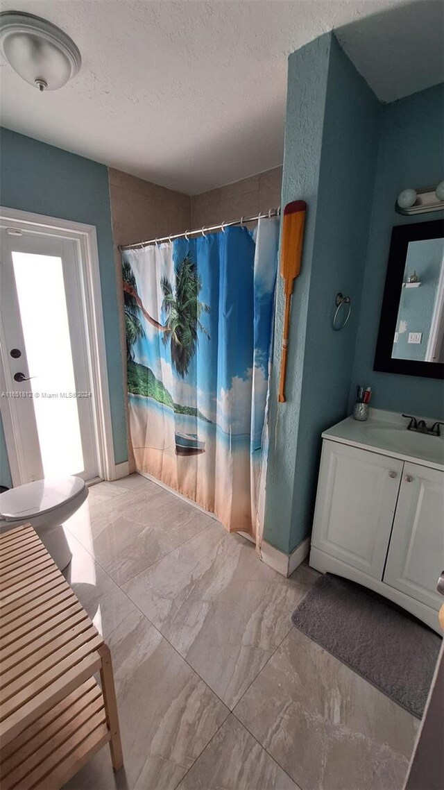 bathroom with vanity, a textured ceiling, and curtained shower