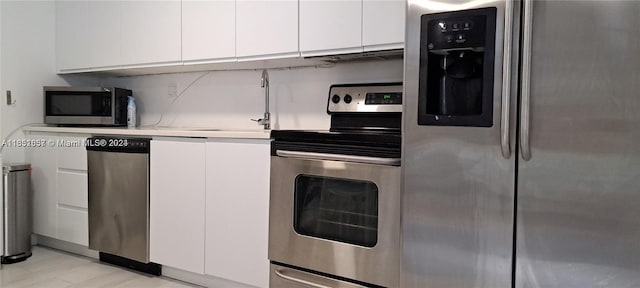 846 Michigan Ave Unit 101, Miami Beach, FL 33139 - kitchen featuring appliances with stainless steel finishes, white cabinets, light countertops, and modern cabinets