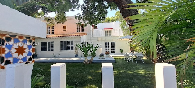 846 Michigan Ave Unit 101, Miami Beach, FL 33139 - back of house with a balcony, a yard, stucco siding, and a tiled roof