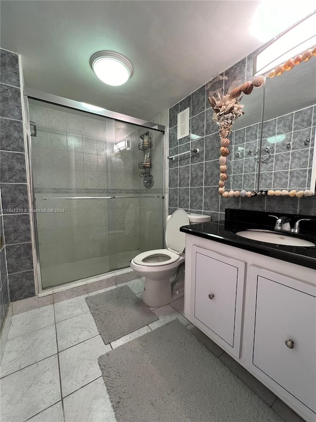 bathroom featuring tile walls, toilet, an enclosed shower, and vanity