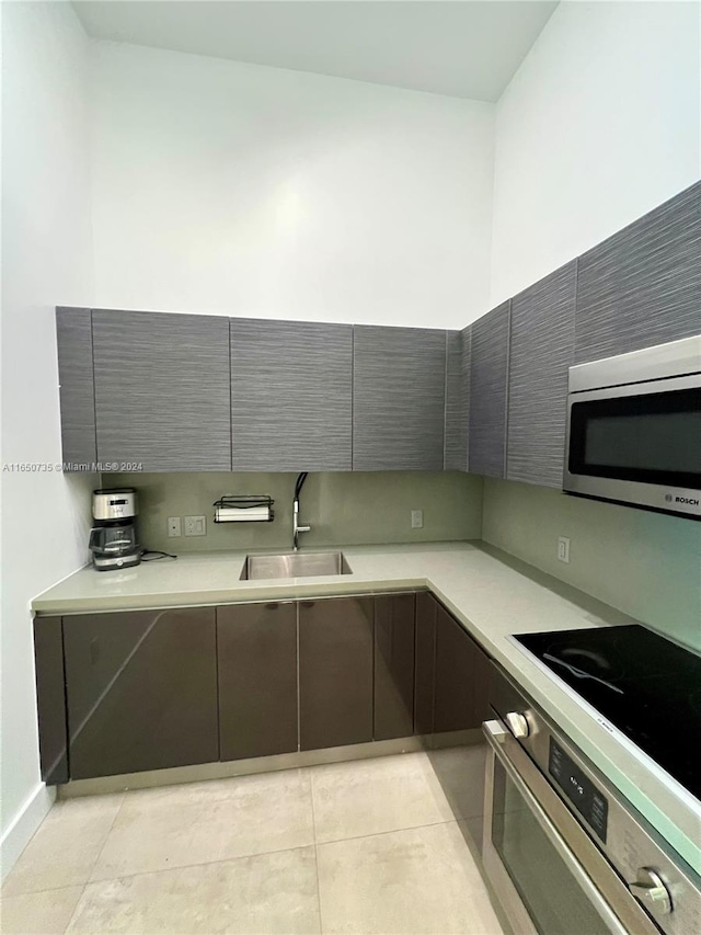 kitchen featuring sink, light tile patterned floors, and appliances with stainless steel finishes