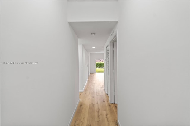 hallway with light hardwood / wood-style floors