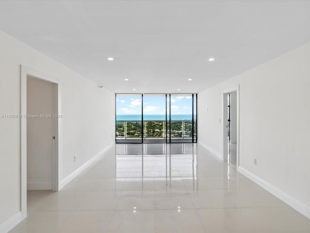 tiled spare room featuring floor to ceiling windows