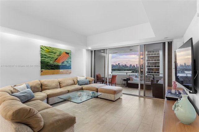 living room with plenty of natural light, a wall of windows, and light hardwood / wood-style floors