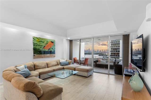 living room with a wall of windows and light hardwood / wood-style flooring