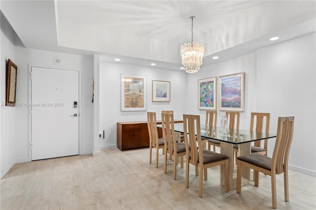 dining space featuring light wood-type flooring and a notable chandelier