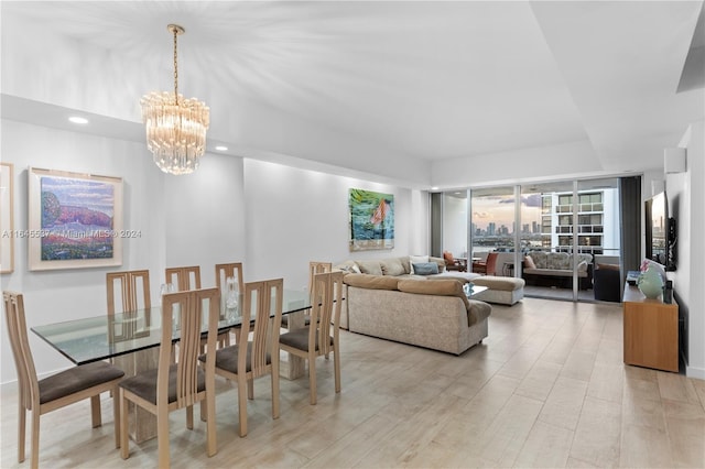 dining space featuring light wood-type flooring and an inviting chandelier