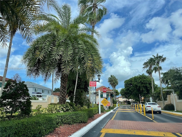 view of road featuring traffic signs, curbs, and a gated entry