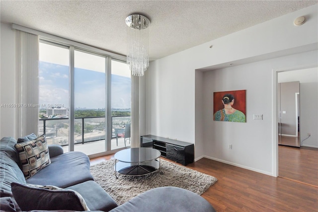 3470 E Coast Ave Unit H1203, Miami, FL 33137 - living room with a chandelier, wood finished floors, a textured ceiling, floor to ceiling windows, and baseboards