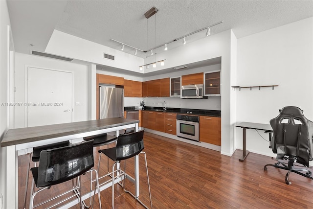 kitchen featuring dark hardwood / wood-style flooring, stainless steel appliances, sink, and a textured ceiling