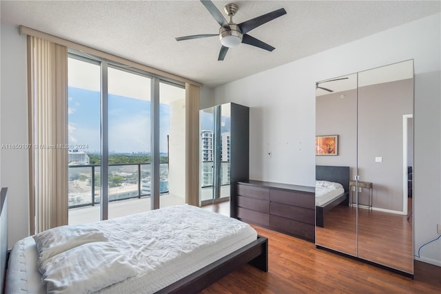 bedroom featuring a textured ceiling, floor to ceiling windows, ceiling fan, and hardwood / wood-style flooring