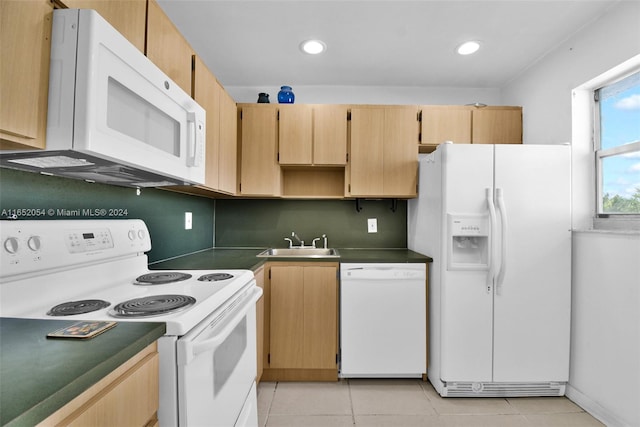 kitchen with white appliances, light tile patterned flooring, and sink