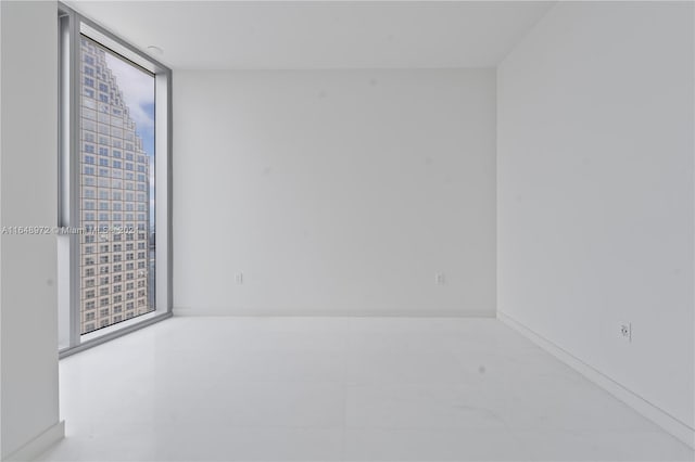 unfurnished room with a wall of windows