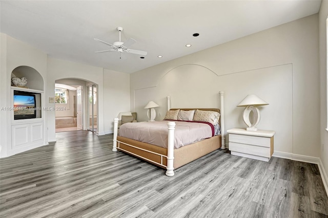 bedroom featuring ceiling fan, ensuite bathroom, and light hardwood / wood-style flooring