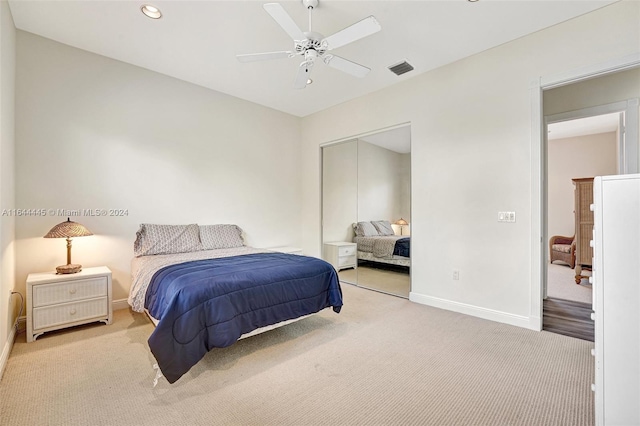 bedroom featuring ceiling fan, a closet, and light carpet