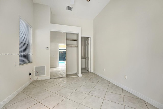 unfurnished bedroom featuring a closet, vaulted ceiling, and light tile patterned flooring