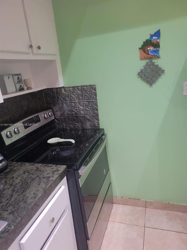 kitchen with white cabinets, stainless steel range with electric cooktop, and light tile patterned flooring